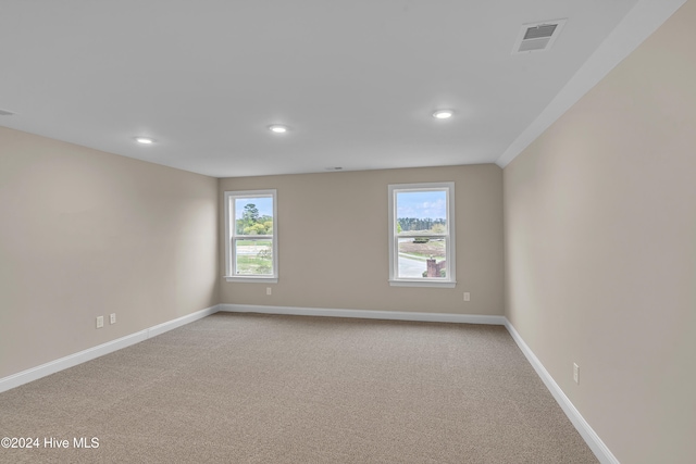 unfurnished room featuring light colored carpet