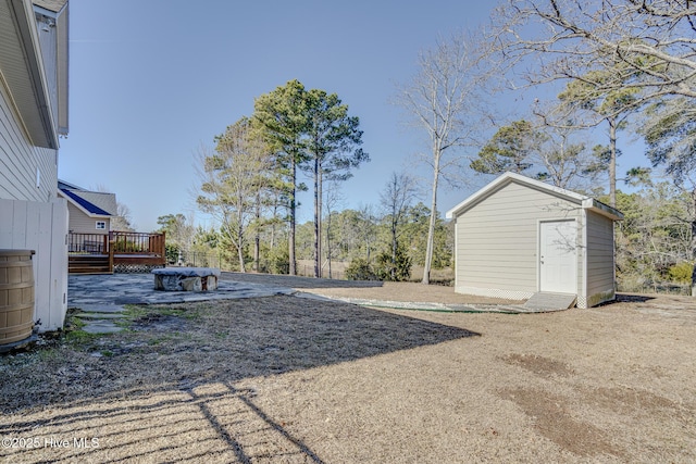 view of yard featuring a deck and a storage shed