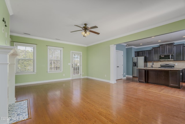 unfurnished living room featuring light wood-type flooring, ceiling fan, crown molding, and sink