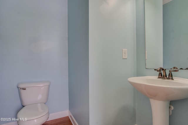 bathroom with hardwood / wood-style flooring, sink, and toilet