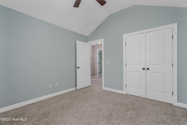 unfurnished bedroom featuring ceiling fan, a closet, vaulted ceiling, and light carpet