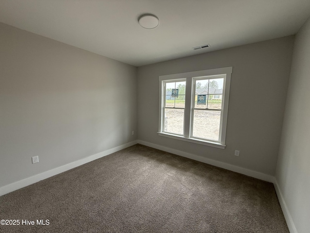 carpeted spare room featuring baseboards