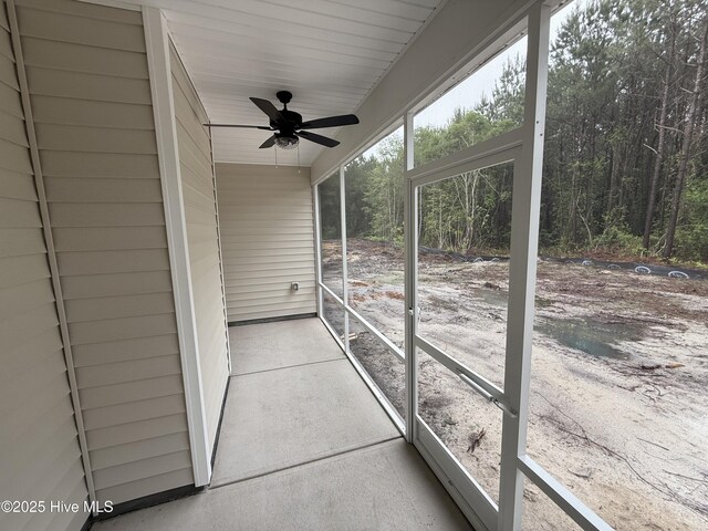 unfurnished sunroom with ceiling fan
