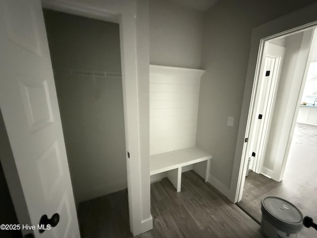 mudroom with dark wood finished floors and baseboards