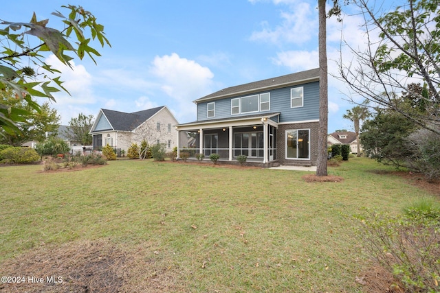 back of property featuring a lawn and a sunroom