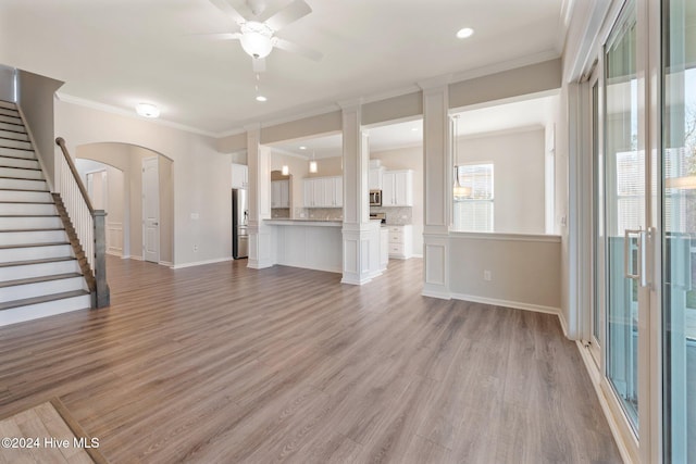 unfurnished living room featuring light hardwood / wood-style flooring, ceiling fan, and crown molding