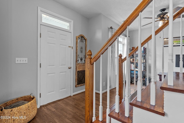 foyer entrance with ceiling fan, wood-type flooring, and a textured ceiling