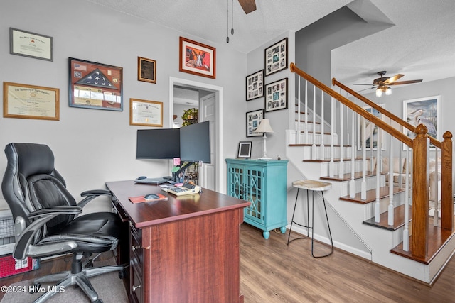 office space featuring hardwood / wood-style flooring, ceiling fan, and a textured ceiling