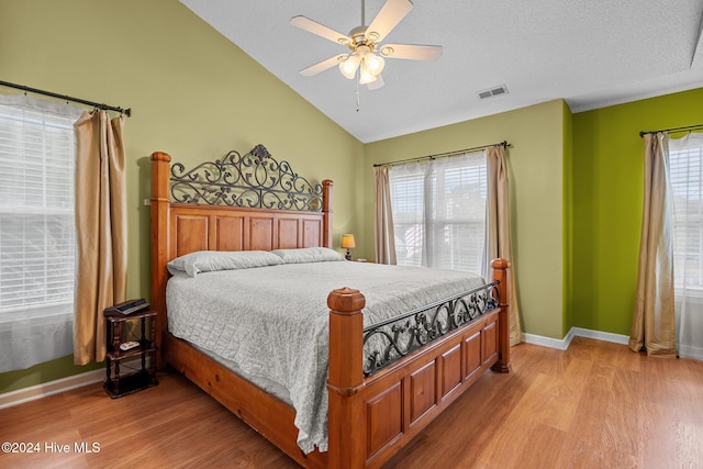 bedroom featuring a textured ceiling, ceiling fan, lofted ceiling, and light wood-type flooring