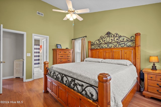 bedroom with hardwood / wood-style floors, ensuite bathroom, and ceiling fan