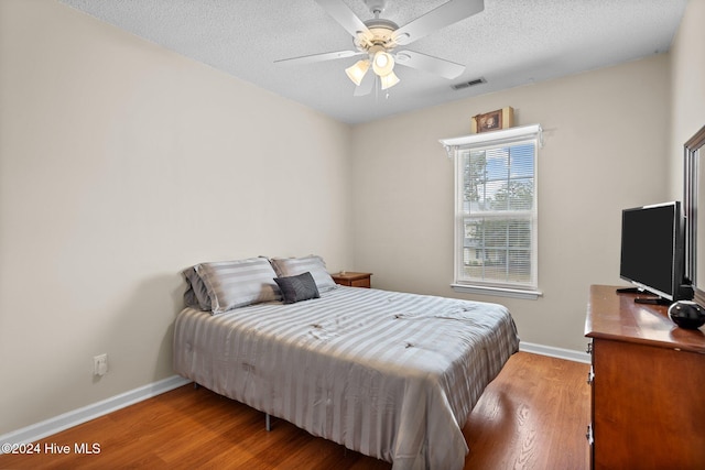 bedroom featuring a textured ceiling, light hardwood / wood-style floors, and ceiling fan