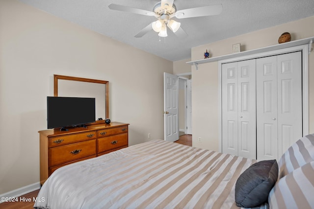 bedroom featuring a textured ceiling, hardwood / wood-style flooring, a closet, and ceiling fan