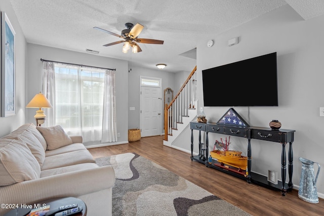 living room featuring ceiling fan, a textured ceiling, and hardwood / wood-style flooring