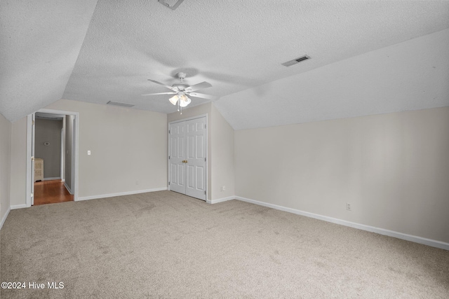 bonus room featuring carpet flooring, ceiling fan, a textured ceiling, and vaulted ceiling