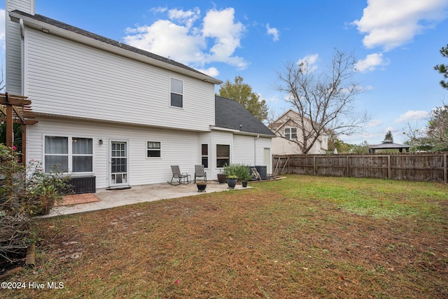 rear view of property featuring a yard and a patio