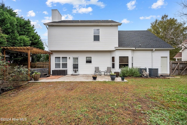 rear view of property featuring a lawn, a pergola, a hot tub, central air condition unit, and a patio