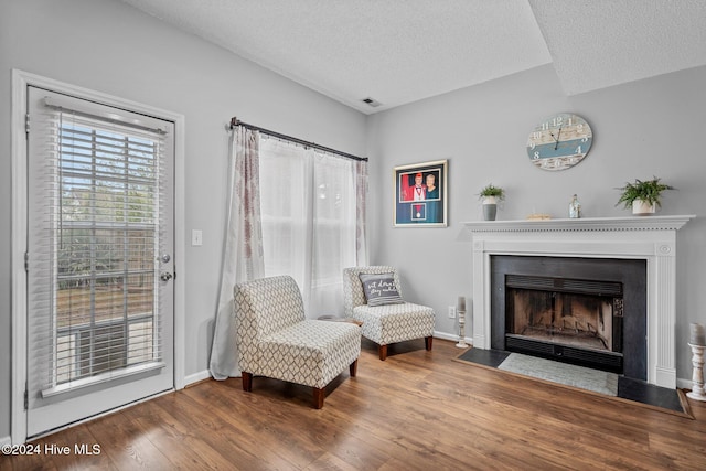 living area featuring a textured ceiling and hardwood / wood-style flooring