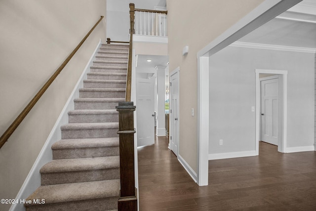 stairway with crown molding and hardwood / wood-style floors