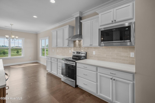 kitchen with appliances with stainless steel finishes, dark hardwood / wood-style flooring, white cabinetry, and wall chimney range hood