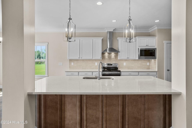 kitchen with sink, wall chimney exhaust hood, light stone counters, white cabinetry, and stainless steel appliances