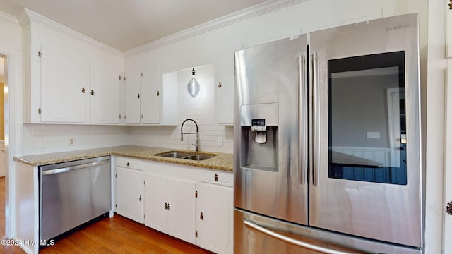 kitchen with light stone countertops, white cabinetry, sink, and appliances with stainless steel finishes