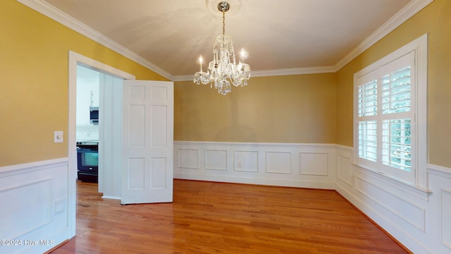 unfurnished dining area featuring hardwood / wood-style floors, a chandelier, and ornamental molding