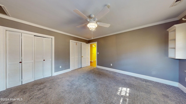 unfurnished bedroom with carpet, ceiling fan, ornamental molding, and multiple closets