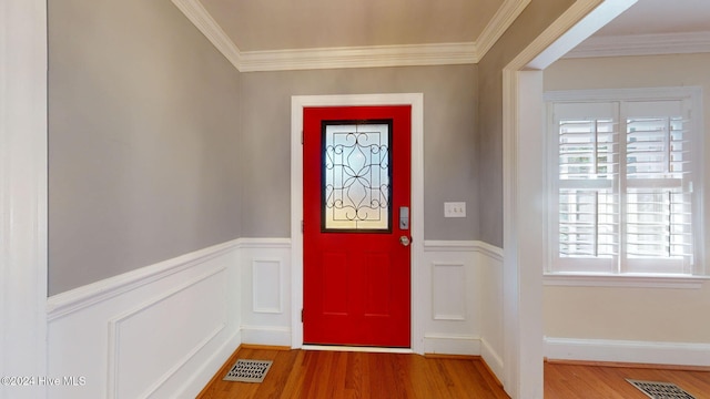 foyer entrance featuring hardwood / wood-style floors and crown molding