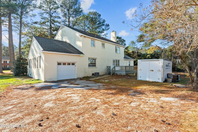 exterior space featuring a deck, central AC unit, and a garage