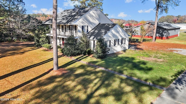 view of home's exterior featuring a lawn and a balcony