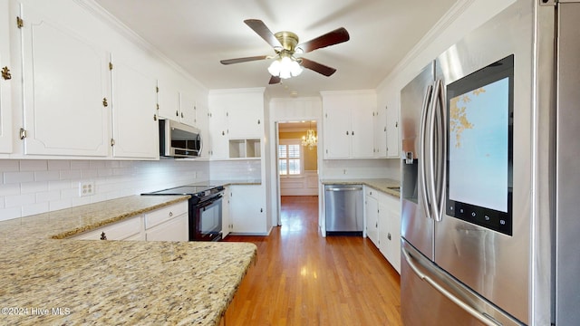 kitchen with white cabinetry, stainless steel appliances, and light stone counters