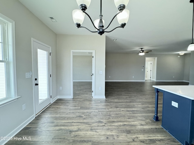 kitchen with visible vents, pendant lighting, a breakfast bar, wood finished floors, and baseboards