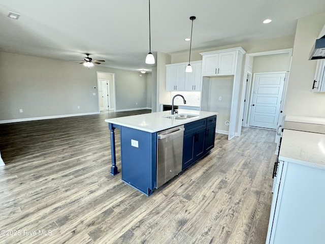 kitchen featuring a sink, blue cabinetry, light countertops, white cabinets, and stainless steel dishwasher