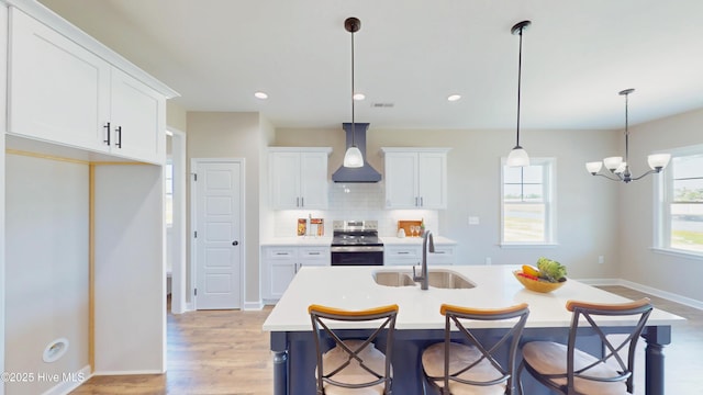 1407 Stoney Creek Church Rd, Goldsboro, NC 27534 - kitchen with stainless steel electric stove, a sink, custom exhaust hood, light countertops, and white cabinets