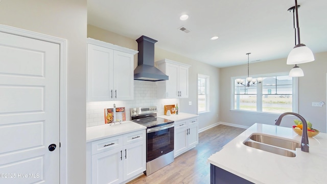 1407 Stoney Creek Church Rd, Goldsboro, NC 27534 - kitchen featuring stainless steel electric stove, wall chimney range hood, a sink, backsplash, and white cabinets