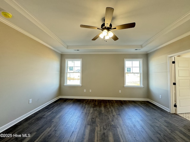 unfurnished room with a raised ceiling, a healthy amount of sunlight, and dark hardwood / wood-style flooring