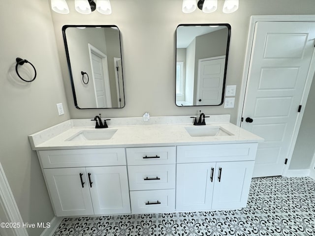 full bathroom with double vanity, baseboards, and a sink