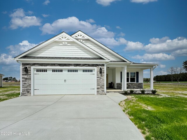 view of front of home with stone siding, covered porch, concrete driveway, and a garage