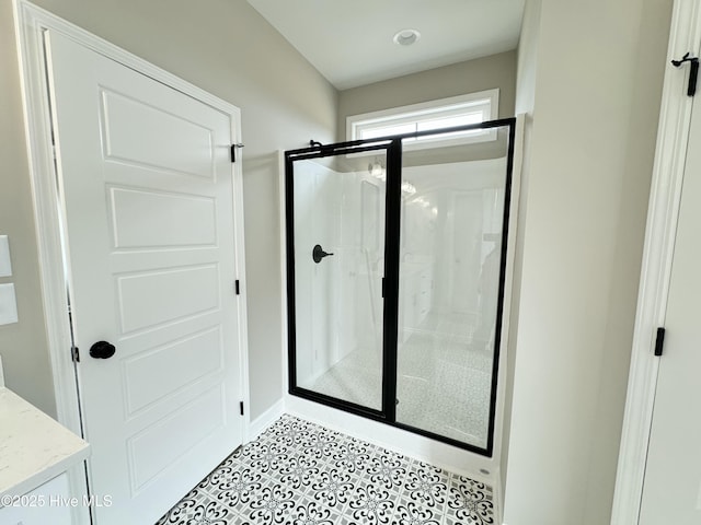 bathroom with tile patterned floors, a shower stall, and vanity