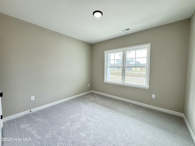 empty room featuring carpet flooring, baseboards, and visible vents