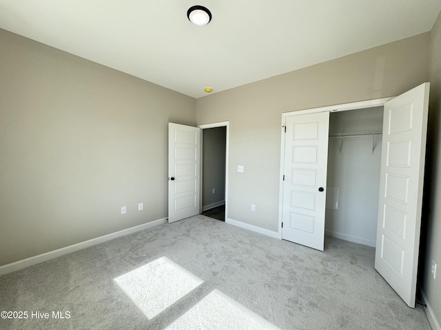 unfurnished bedroom with light colored carpet and a closet