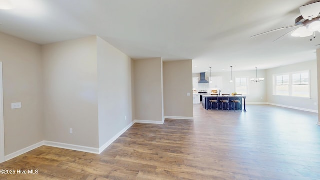 1407 Stoney Creek Church Rd, Goldsboro, NC 27534 - unfurnished living room featuring a ceiling fan, wood finished floors, baseboards, and a chandelier