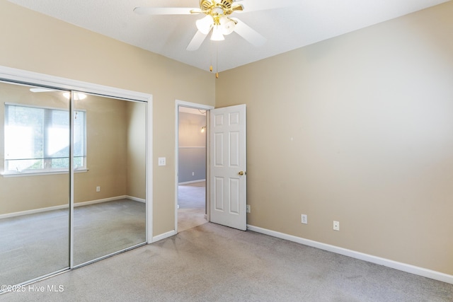 unfurnished bedroom featuring ceiling fan, a closet, and light carpet