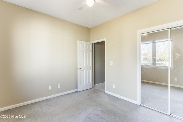 unfurnished bedroom with light colored carpet, a closet, and ceiling fan