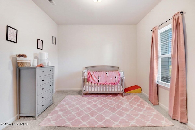 carpeted bedroom with a nursery area