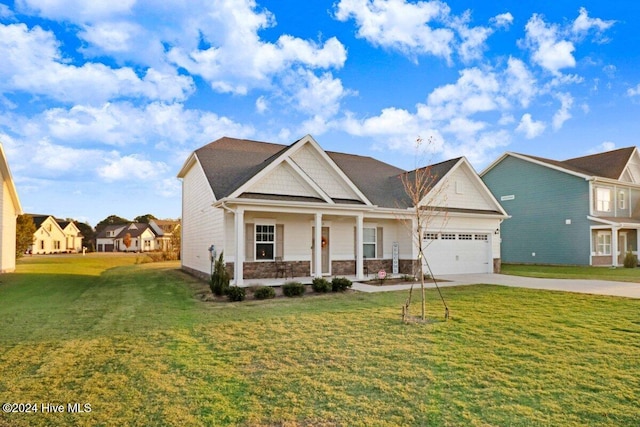 view of front of home featuring a front yard, a porch, and a garage