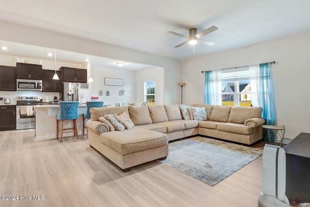 living room featuring light hardwood / wood-style flooring and ceiling fan