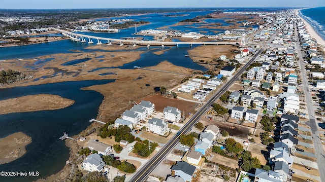 birds eye view of property with a water view and a beach view