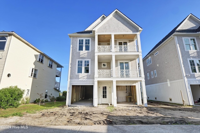 view of front facade with a carport, a balcony, and a garage