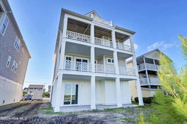 back of house featuring a balcony and board and batten siding